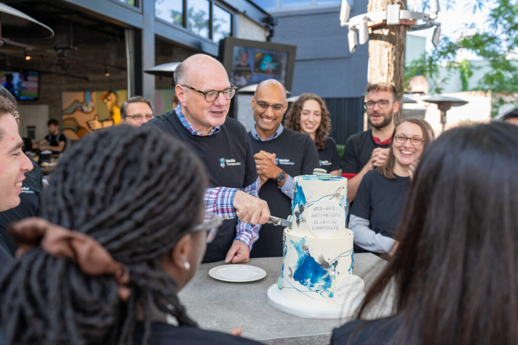 Mediar team members cutting large cake