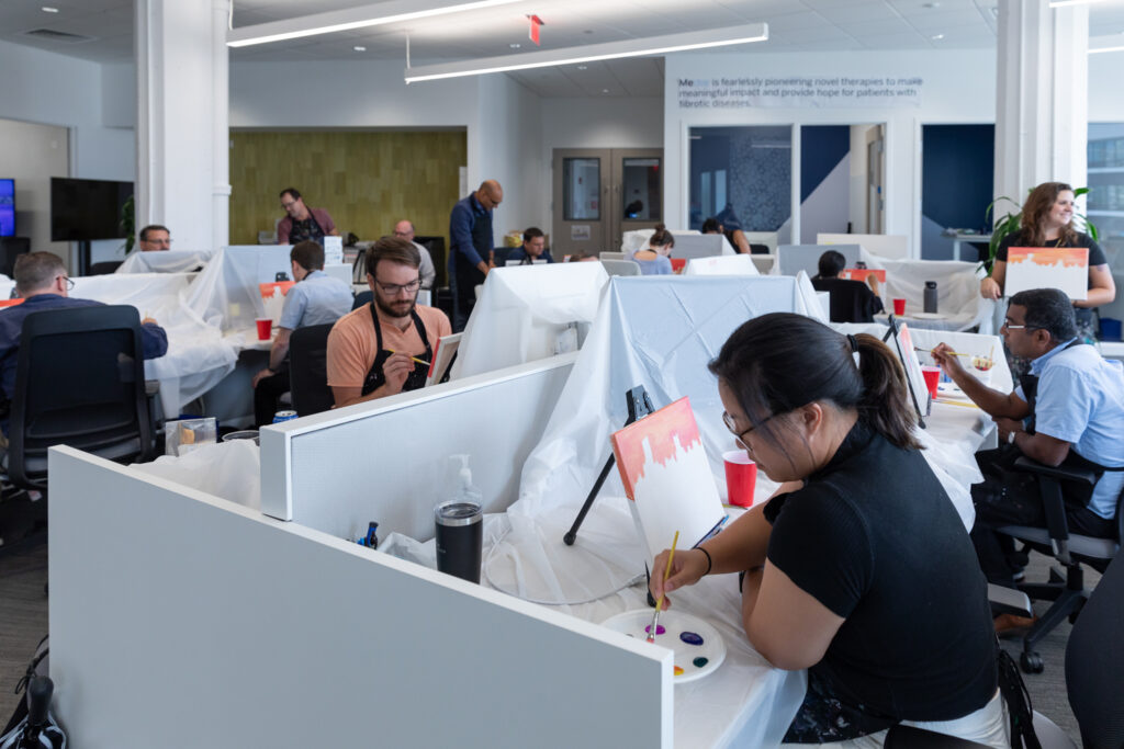 Mediar team members painting on canvas